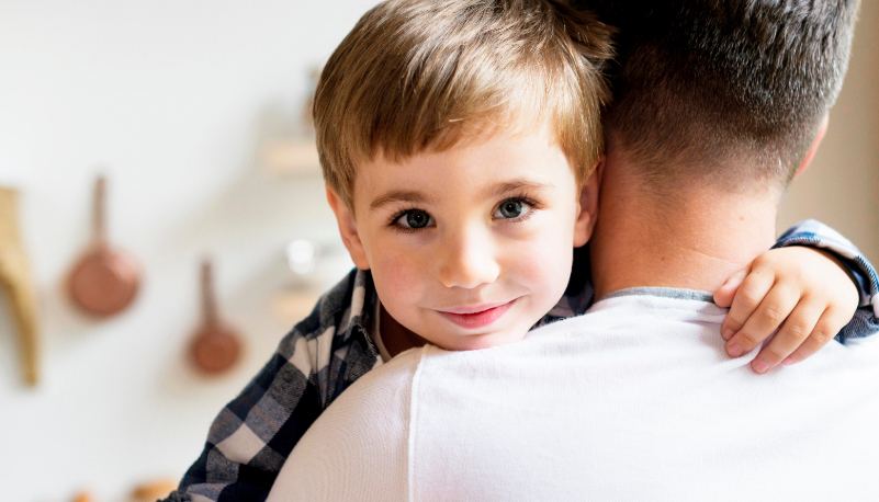 A child hugging a parent at home