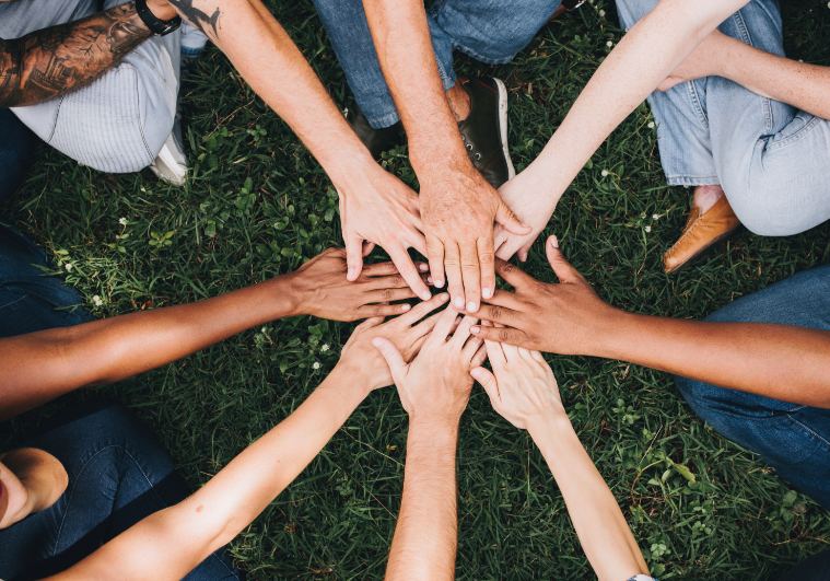 A group of people placing their hands together